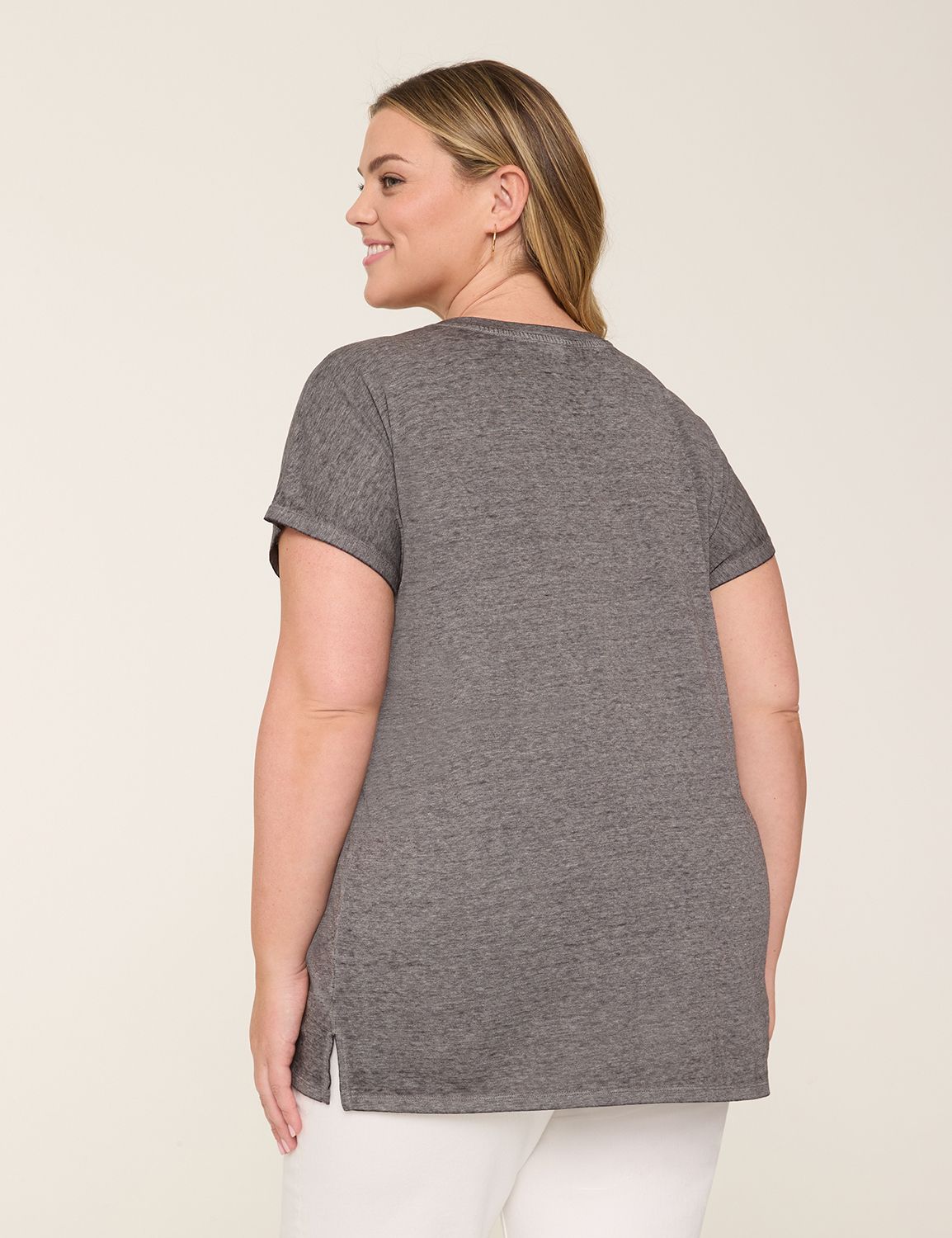 Solid short dolman sleeve top featuring V-neck and pleated hem detail.
